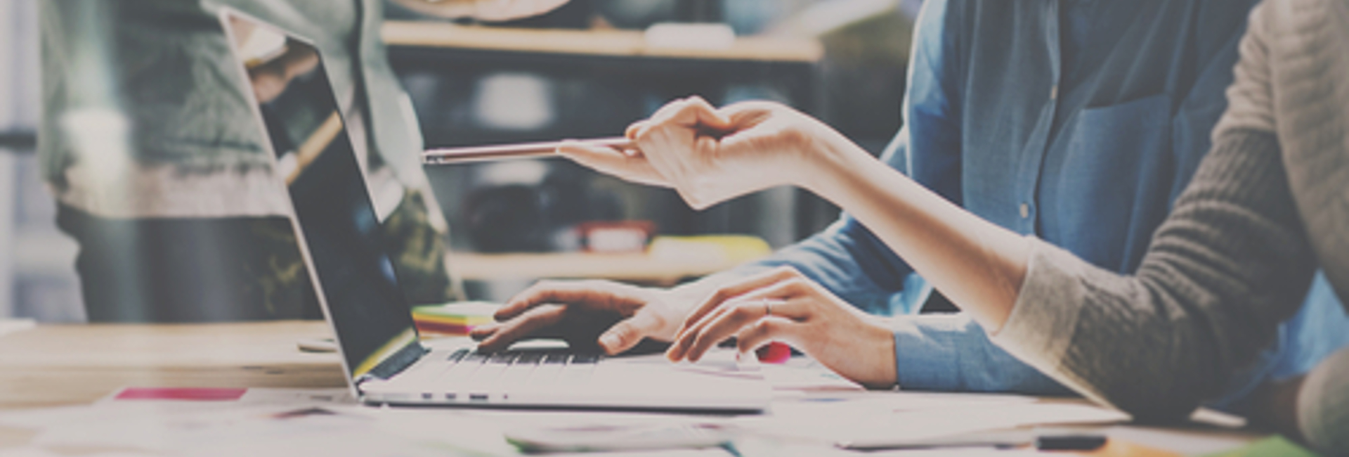 Decision makers looking at a laptop reviewing the benefits of the IT Policy Management as a Service