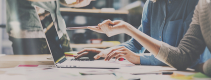 Decision makers looking at a laptop reviewing the benefits of the IT Policy Management as a Service