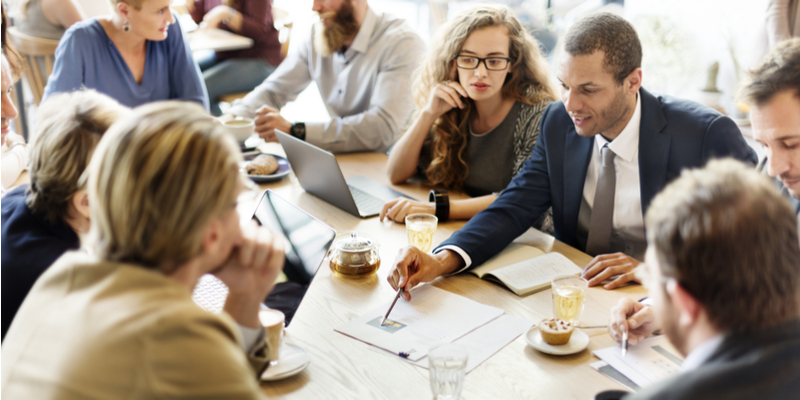 IT consultant going over IT Professional Services with a team of people sitting around a board room table 