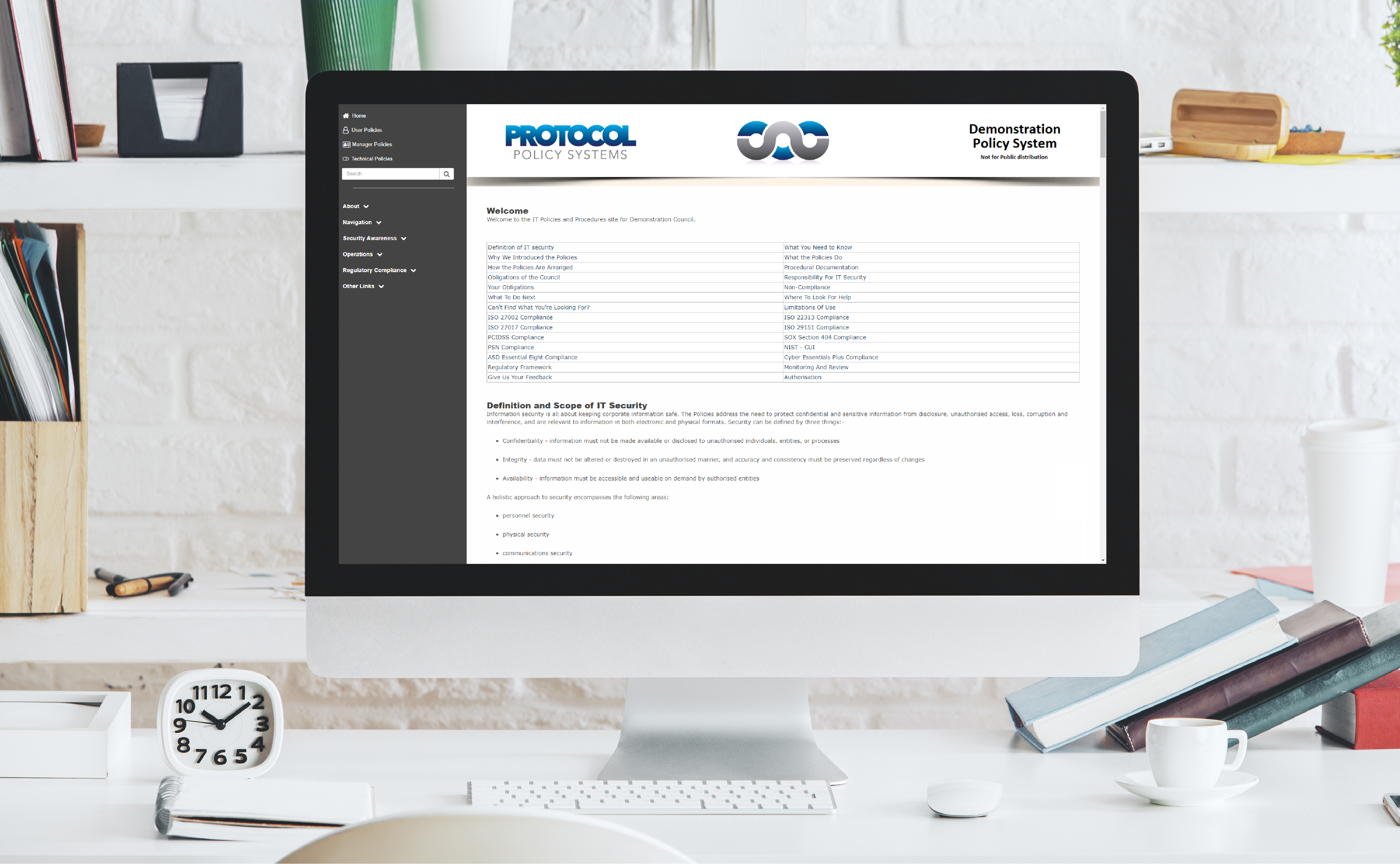 Desk with a monitor displaying the IT Policy Management as a Service platform