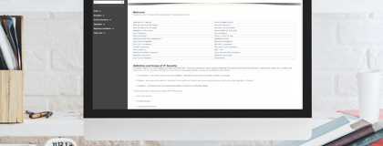 Desk with a monitor displaying the IT Policy Management as a Service platform