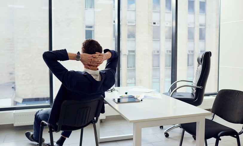 An IT Manager relaxing in a chair knowing that the organisations Microsoft 365 environment is configured securely