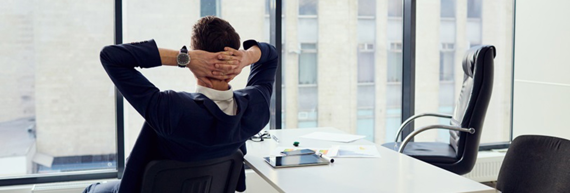 An IT Manager relaxing in a chair knowing that the organisations Microsoft 365 environment is configured securely