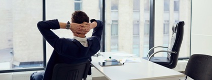 An IT Manager relaxing in a chair knowing that the organisations Microsoft 365 environment is configured securely