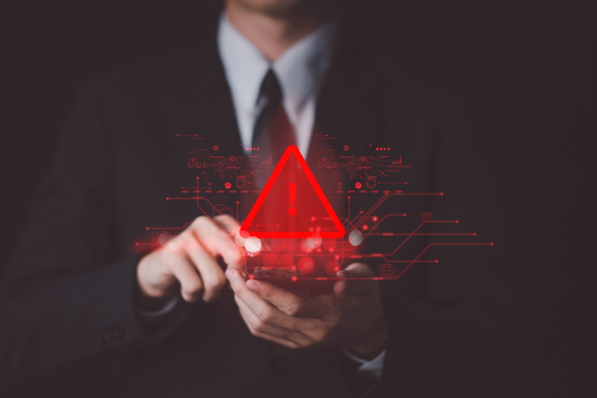 Business man touching a device alerting there has been a breach and IT incident response plan needs to be put into action